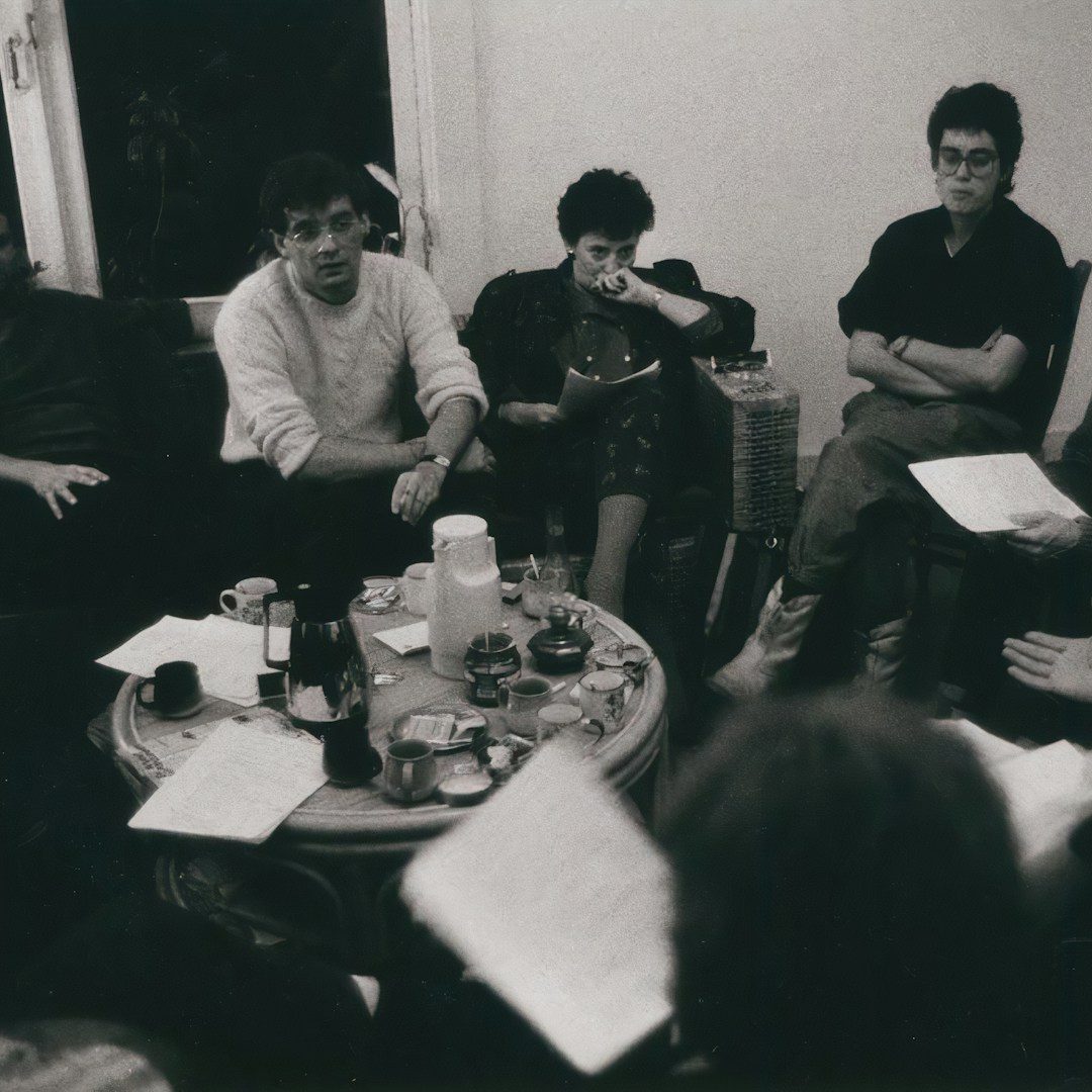 Birch & Ink — About Our Team Four colleagues discussing a project in a modern office setting.